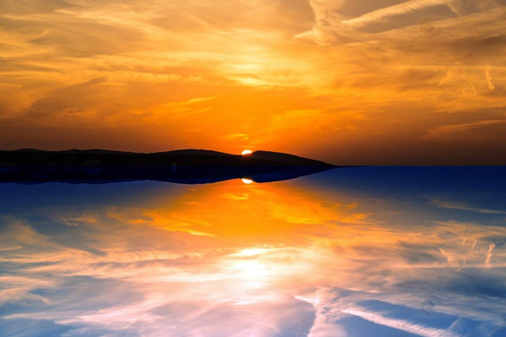 A sunset with the sun reflecting in water.