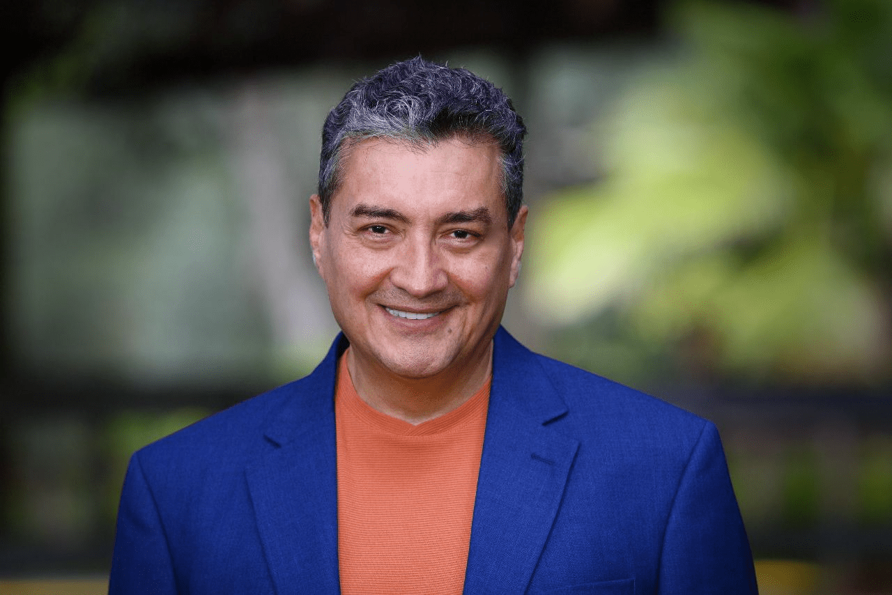 A man in a blue suit and orange shirt.